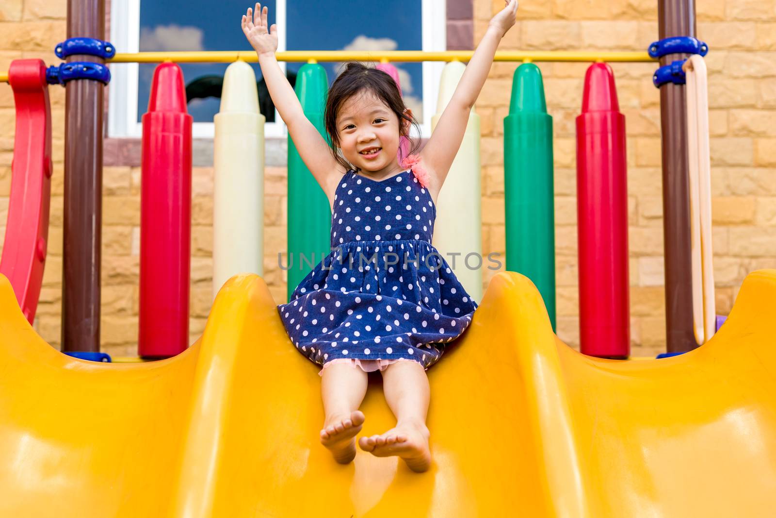 Young girl playing outdoor equipment with happiness.