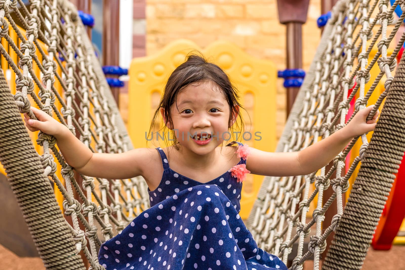 Young girl playing outdoor equipment with happiness.