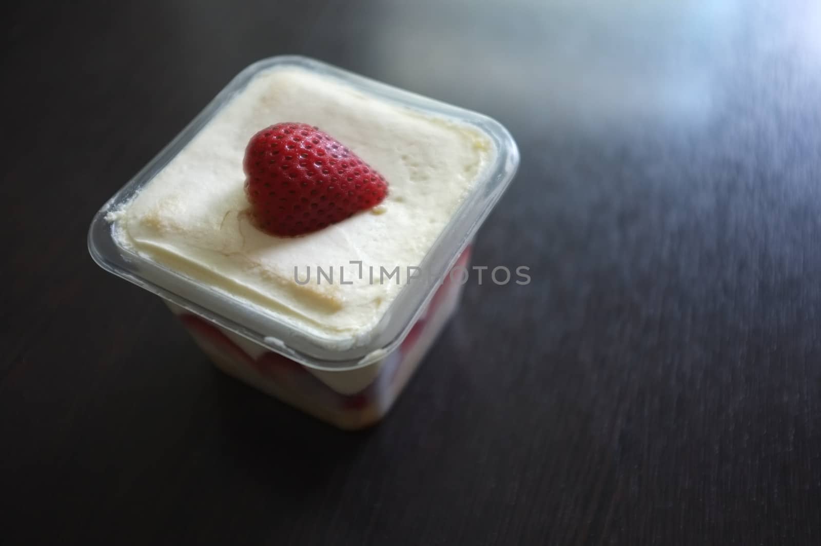 Tasty cupcake with strawberry on black wooden background . Copy space. Place for text.