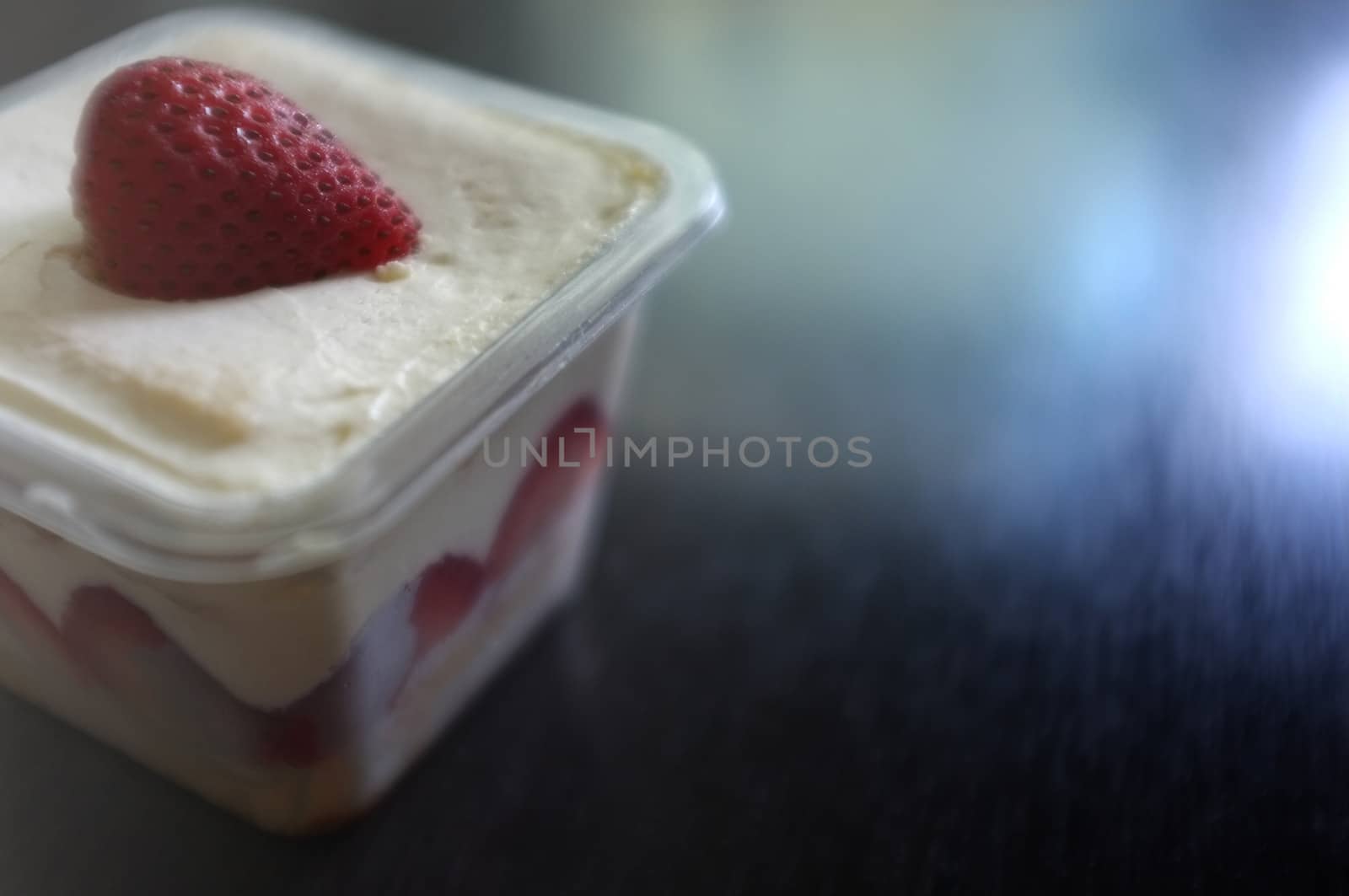 Tasty cupcake with strawberry on black wooden background . Copy space. Place for text.