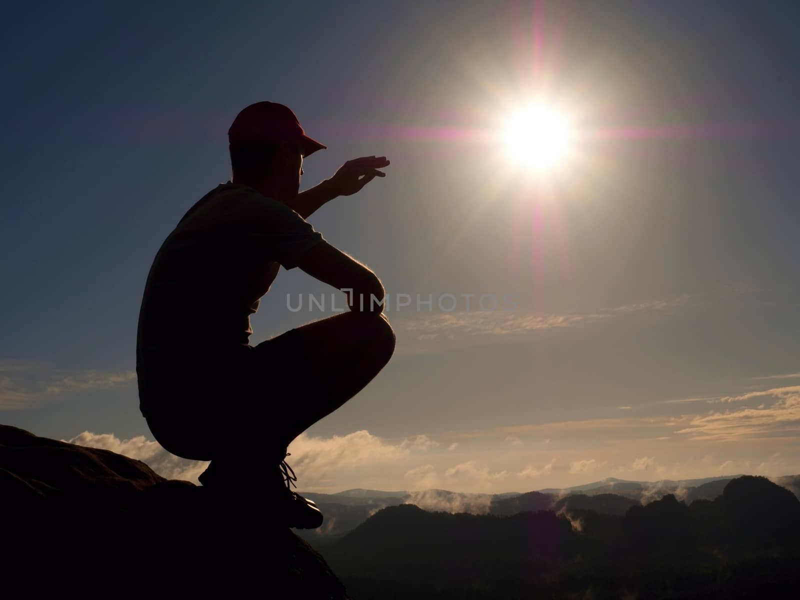 Freedom hiker sit upper the misty valley and enjoy morning in beautiful nature