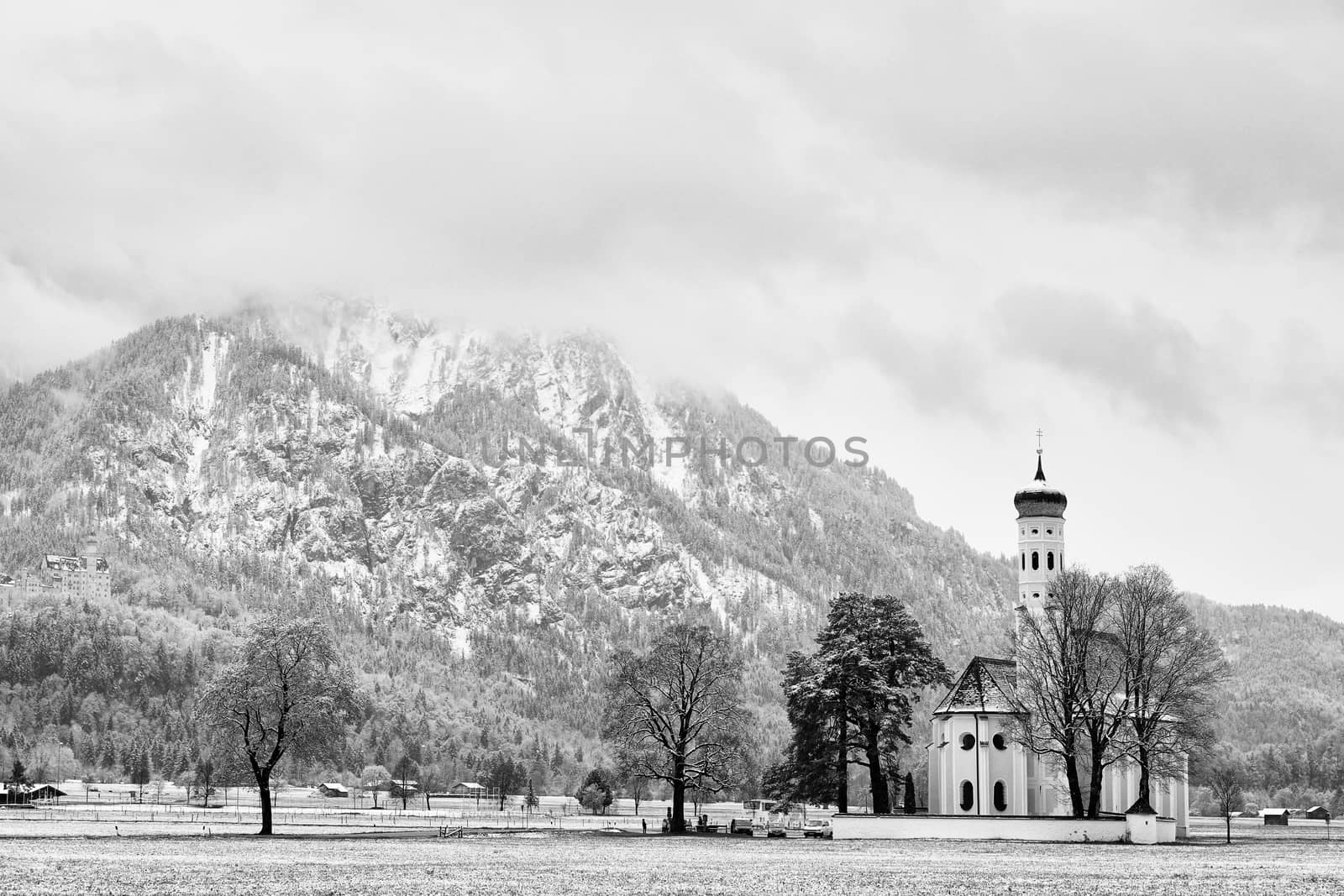 Old church with high bell tower and graveyard bellow mountains.  by rdonar2