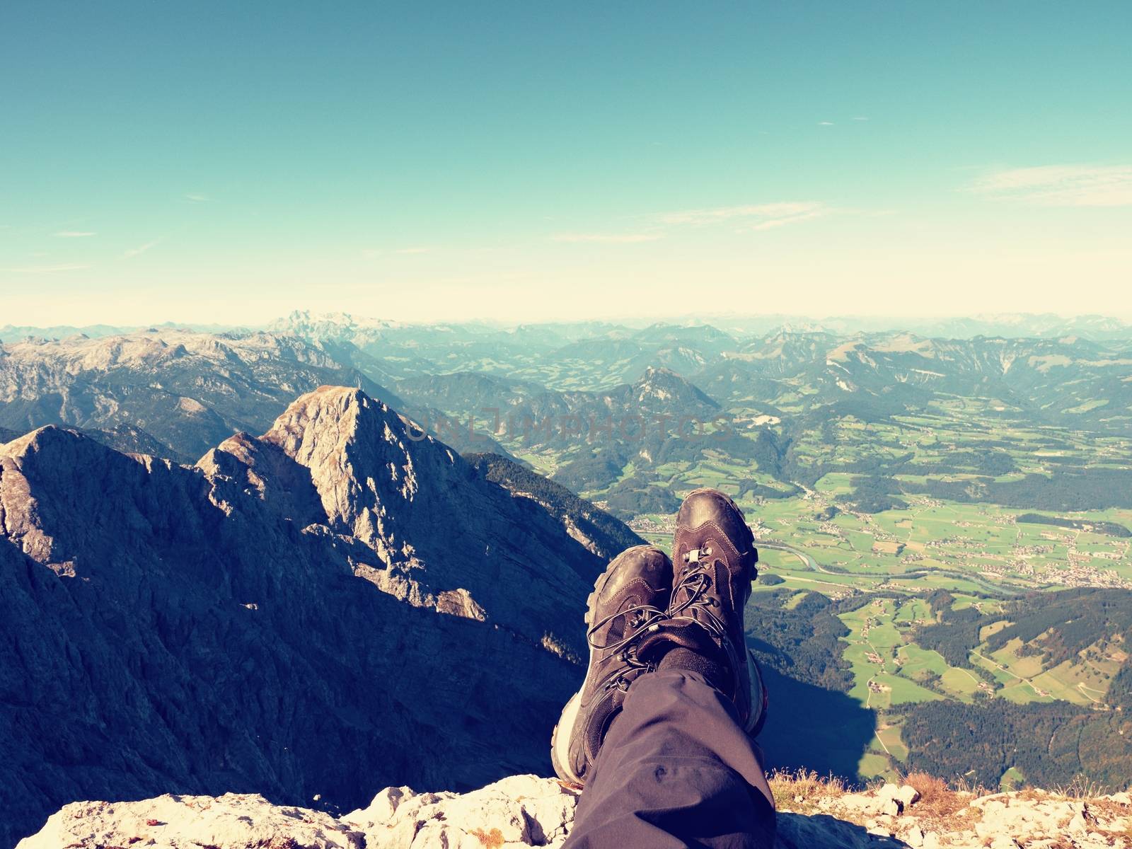 Rest on mountain trail. Man hiker lay on the mountain summit. Feet in trekking boots by rdonar2