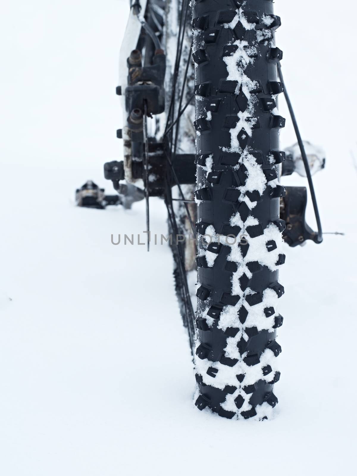 Mountain bike stay in powder snow. Deep snowdrift. Rear wheel detail.  by rdonar2