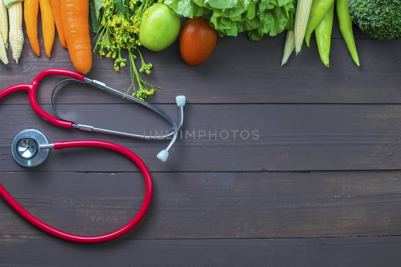 Healthy food, vegetables organic on wooden background with glass of milk and stethoscopes, strong body concept and copy space below.