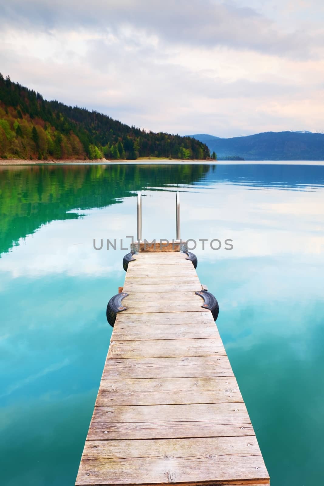 Empty wooden mole on blue Alps lake, wharf for hired boats in marina. Ready for trip ships. by rdonar2