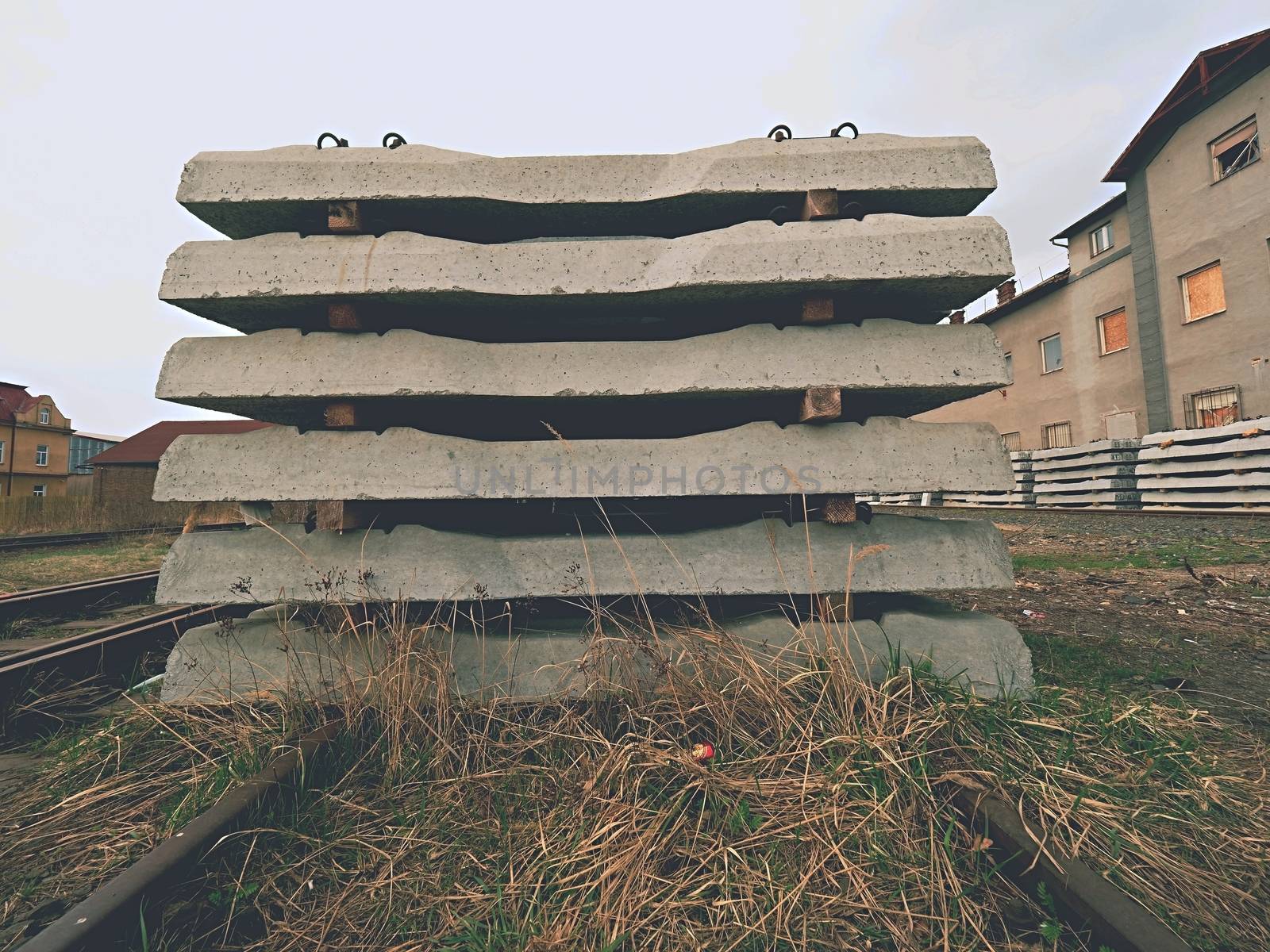 Sleepers stock in railway depot. New concrete railway ties stored for reconstruction of old railway station. by rdonar2