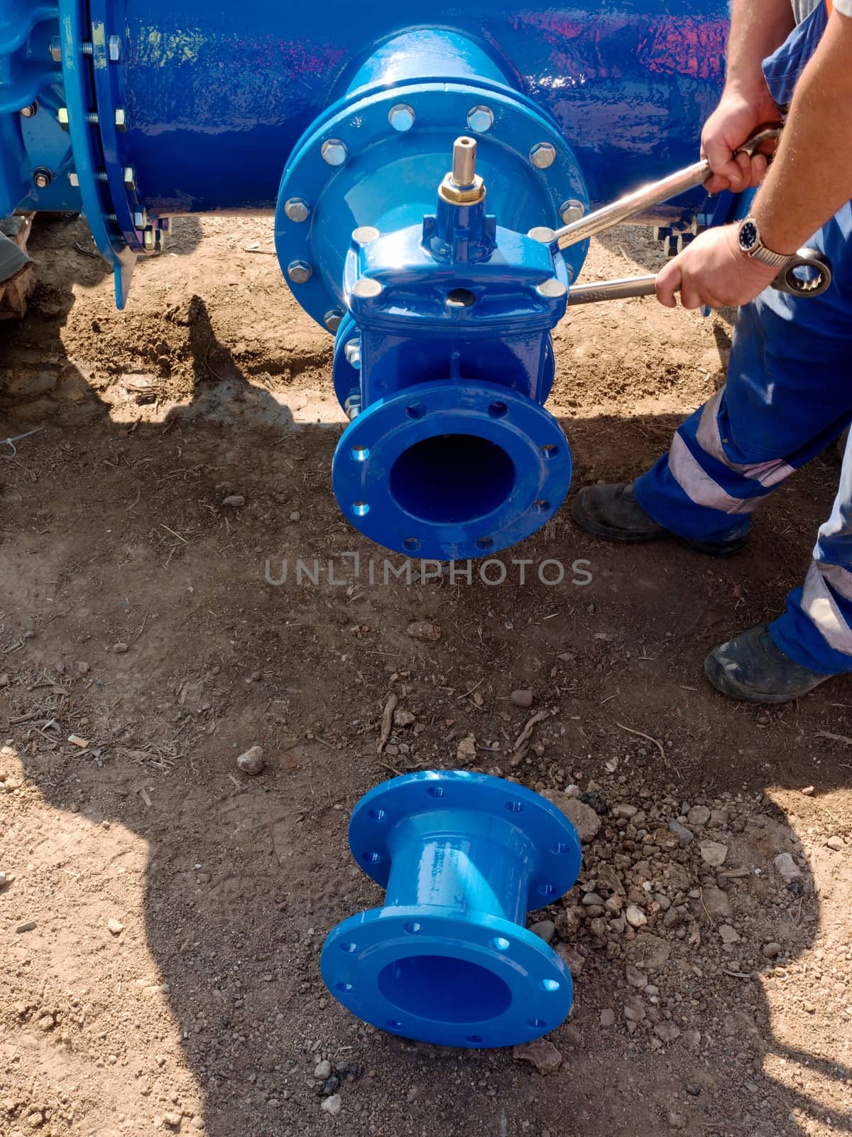 Worker hands screwing  nuts on new dring water piping. by rdonar2