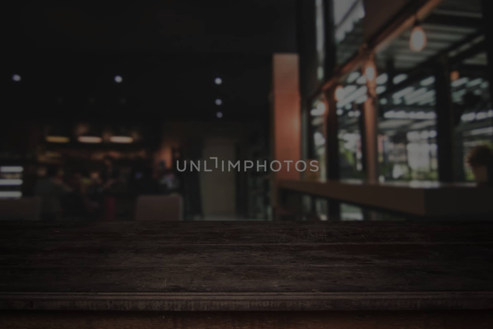 Old wood table in front of blurred cafe restaurant background, copy space can be placed your product.