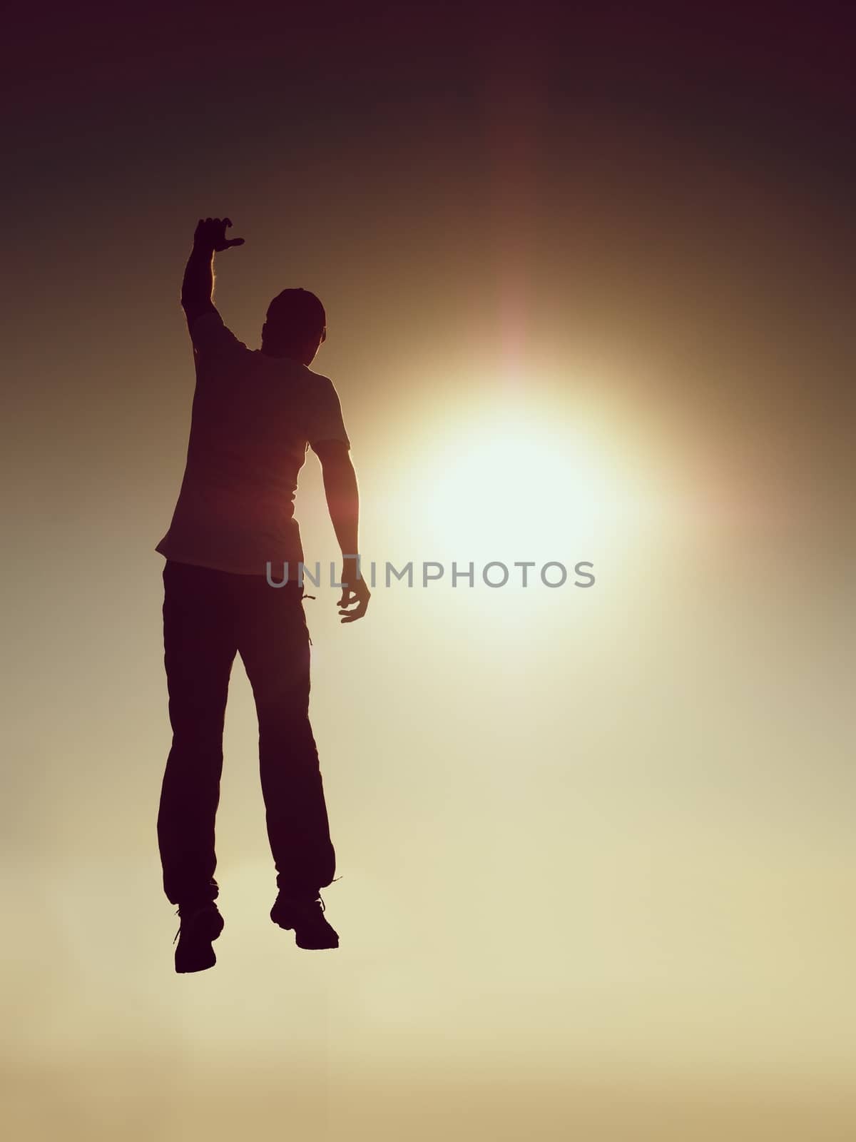 Jumping man. Young crazy man is jumping on red sky background.Silhouette of jumping man and beautiful sunset sky. Element of design by rdonar2