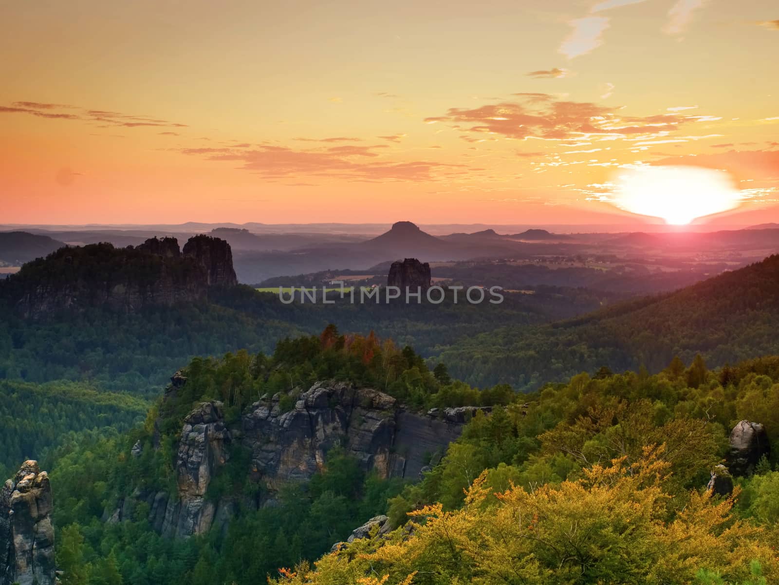 Sunset above sharp sandstone cliffs above deep valley. Popular climbers resort. Deep cracks in rocks donne by strong rain erosion