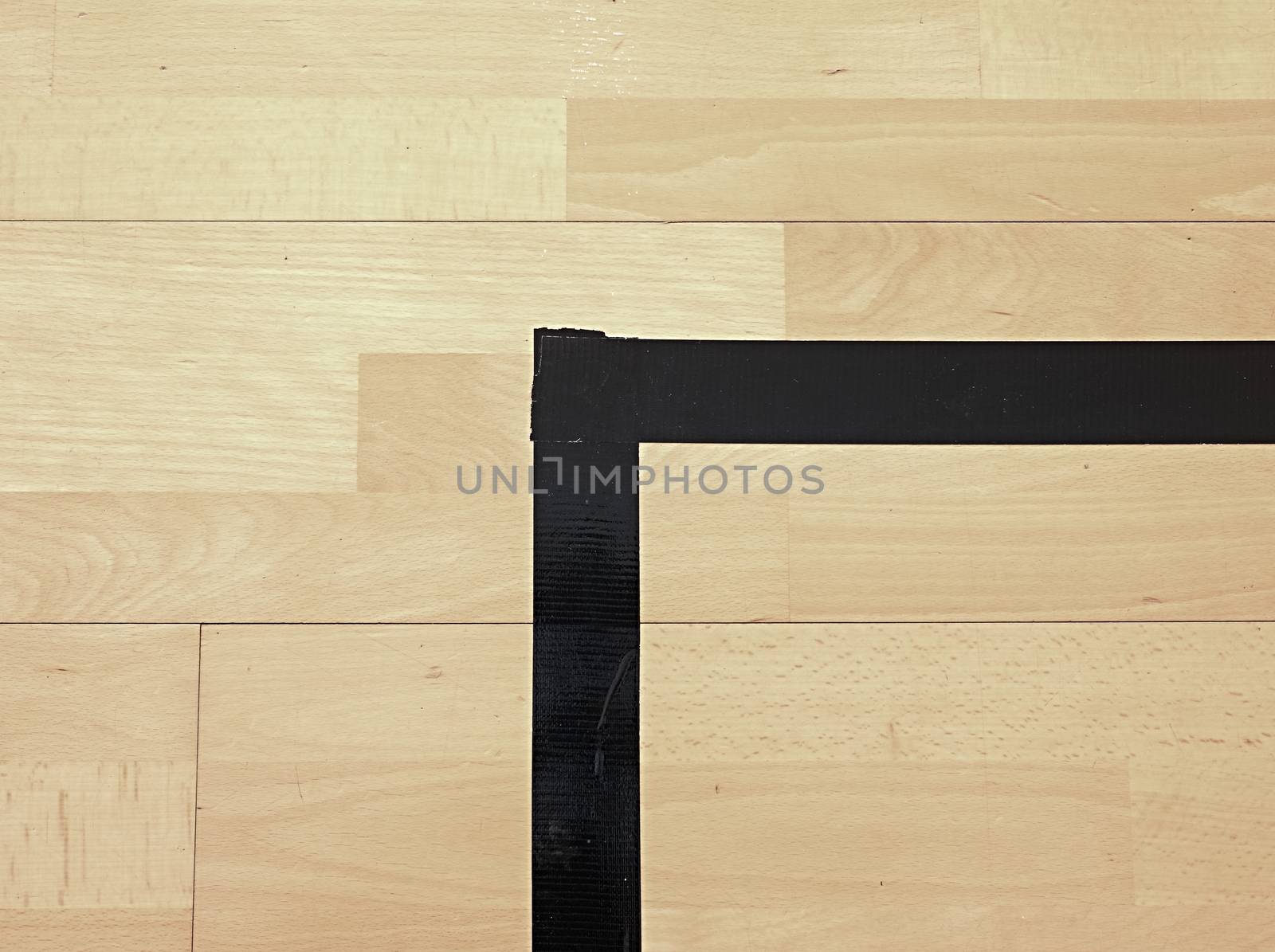 Black corner. Worn out wooden floor of sports hall with colorful marking lines