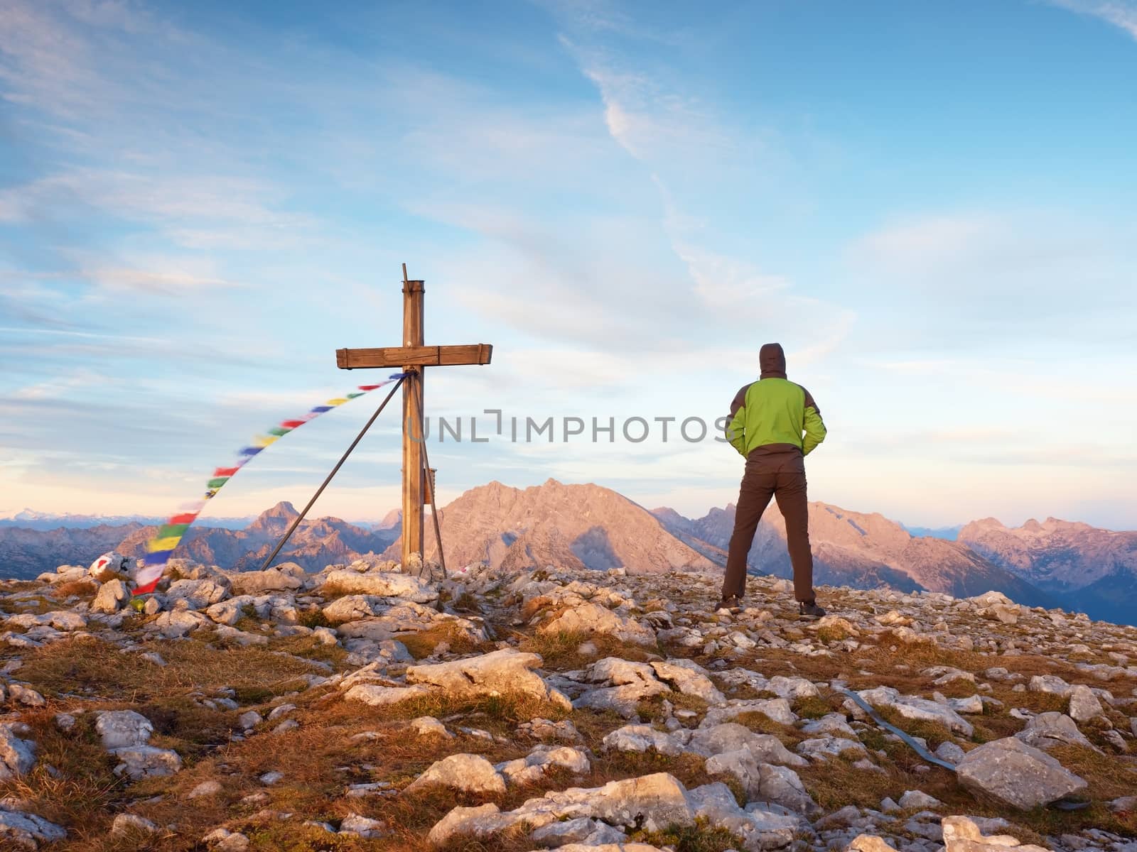Man walk along the wooden cross at a mountain peak built to Alps victiims. Cross on top  by rdonar2