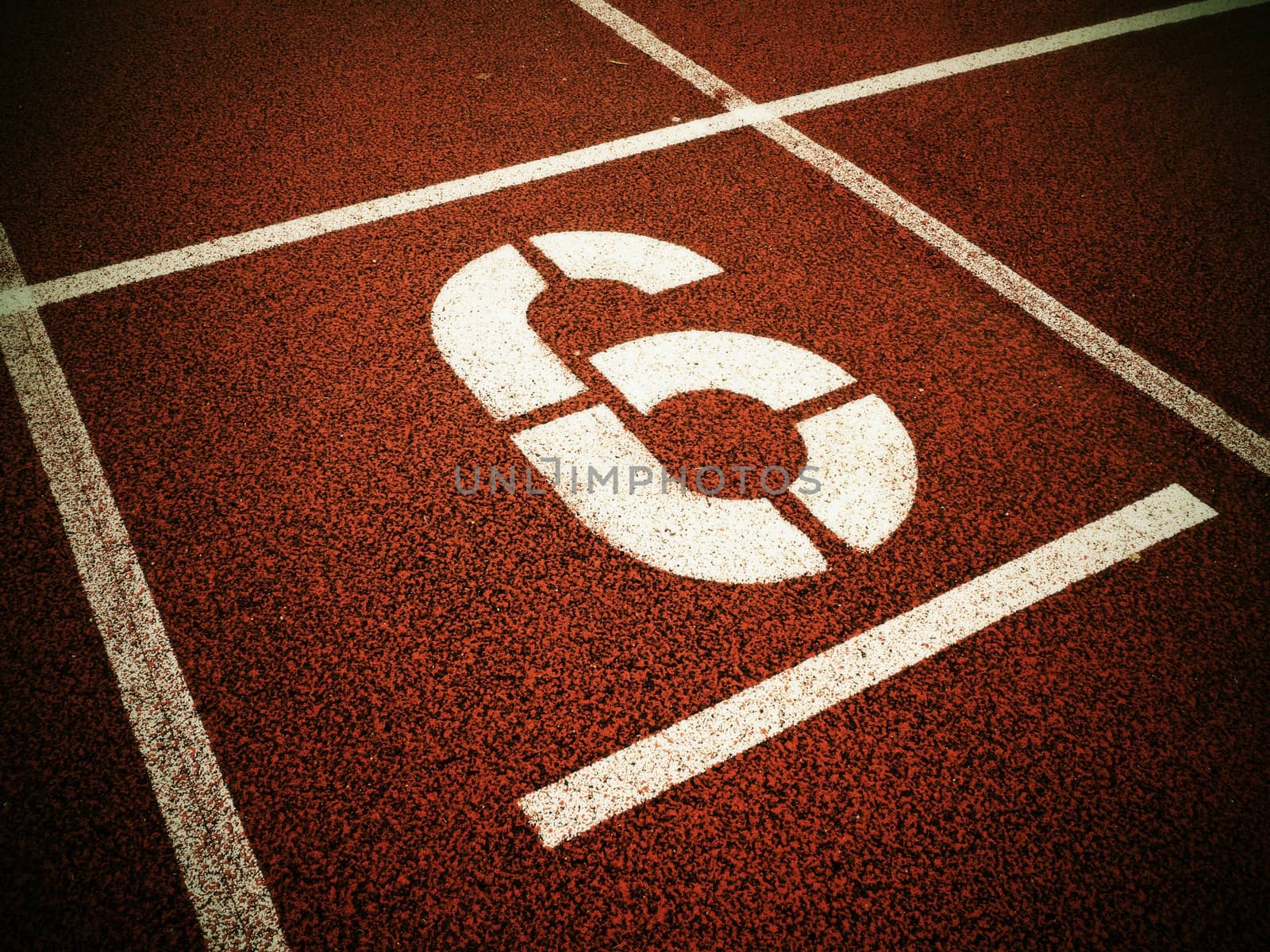 Number six. White athletic track number on red rubber racetrack, texture of running racetracks in stadium