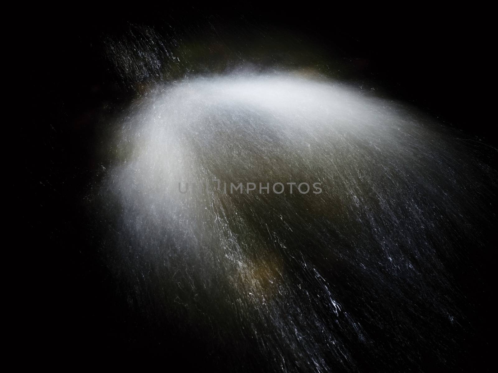 Shinning drops. Cascade of small weir on mountain stream, water is running over blocks and bubbles create milky smoky water level. Abstract, long exposure photo