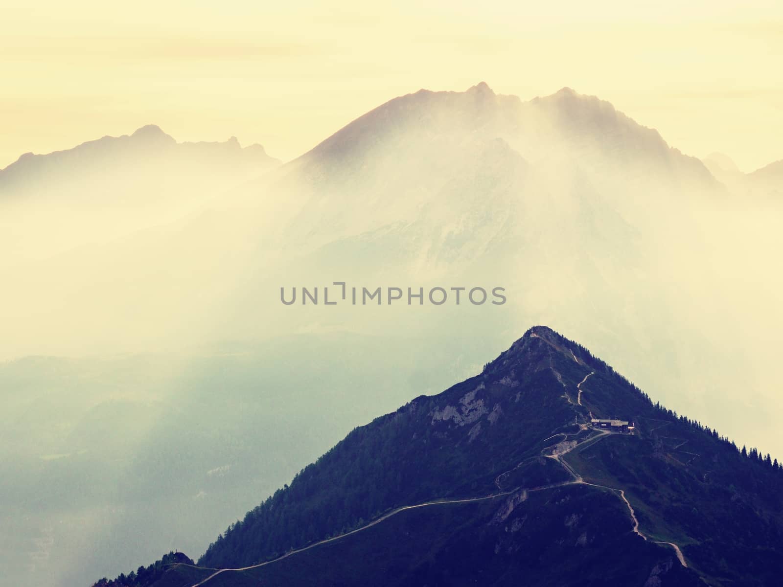 Sharp Alps peaks, rocks without people. View over Alpine rocks above deep vallyes to far horizon. Sunny day with clear blue sky  