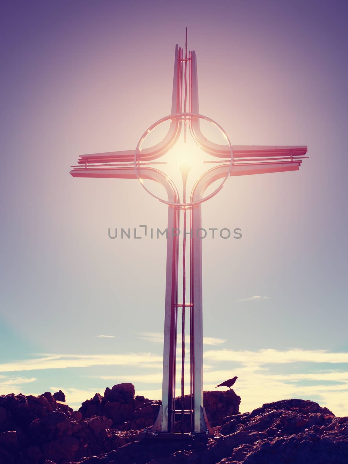 Shinning cross on high rocky mountain. Steel artistic crucifix on top of Alpine mountain, by rdonar2