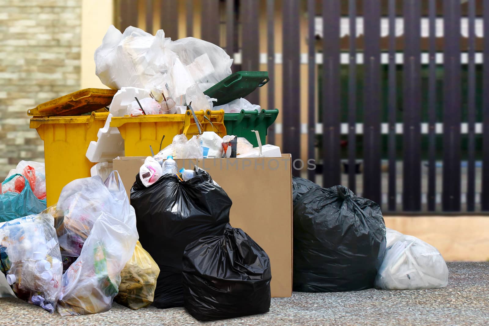 lots waste bin recycle and garbage plastic bags at the fence home, many trash waste plastic bags front house, pollution garbage waste, lots of junk dump, plastic garbage waste is environment pollution