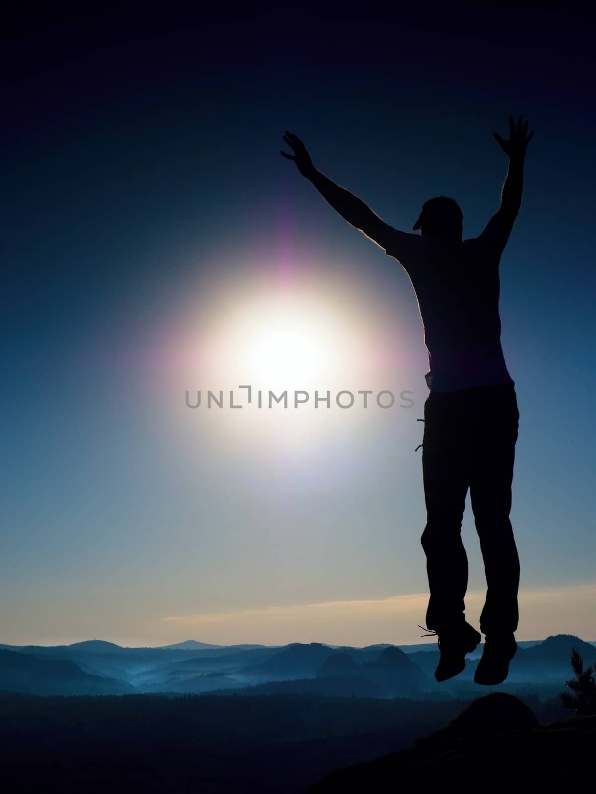  Jumping man. Young crazy man is jumping on colorful sky background. Silhouette of jumping man and beautiful sunset sky. Element of design. Vintage effect.