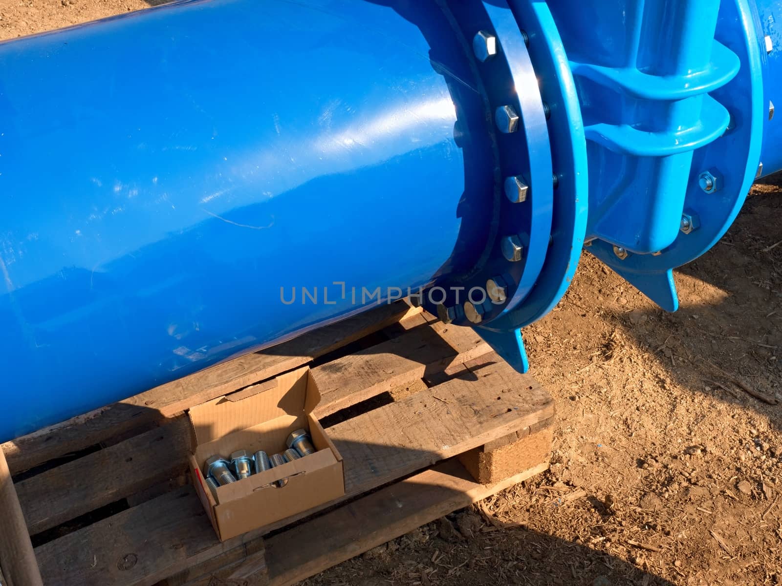 Detail of 500mm big new drink water joint unit with screws and nuts. Collar pipe fitting. Piping repair,  fasteners and spare parts on wooden pallet .