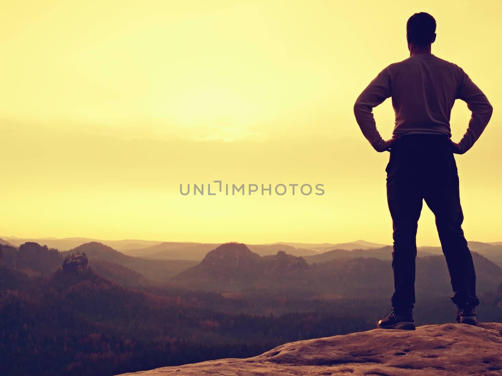 A man has his hands on hips. Sportsman silhouette in nature within daybreak