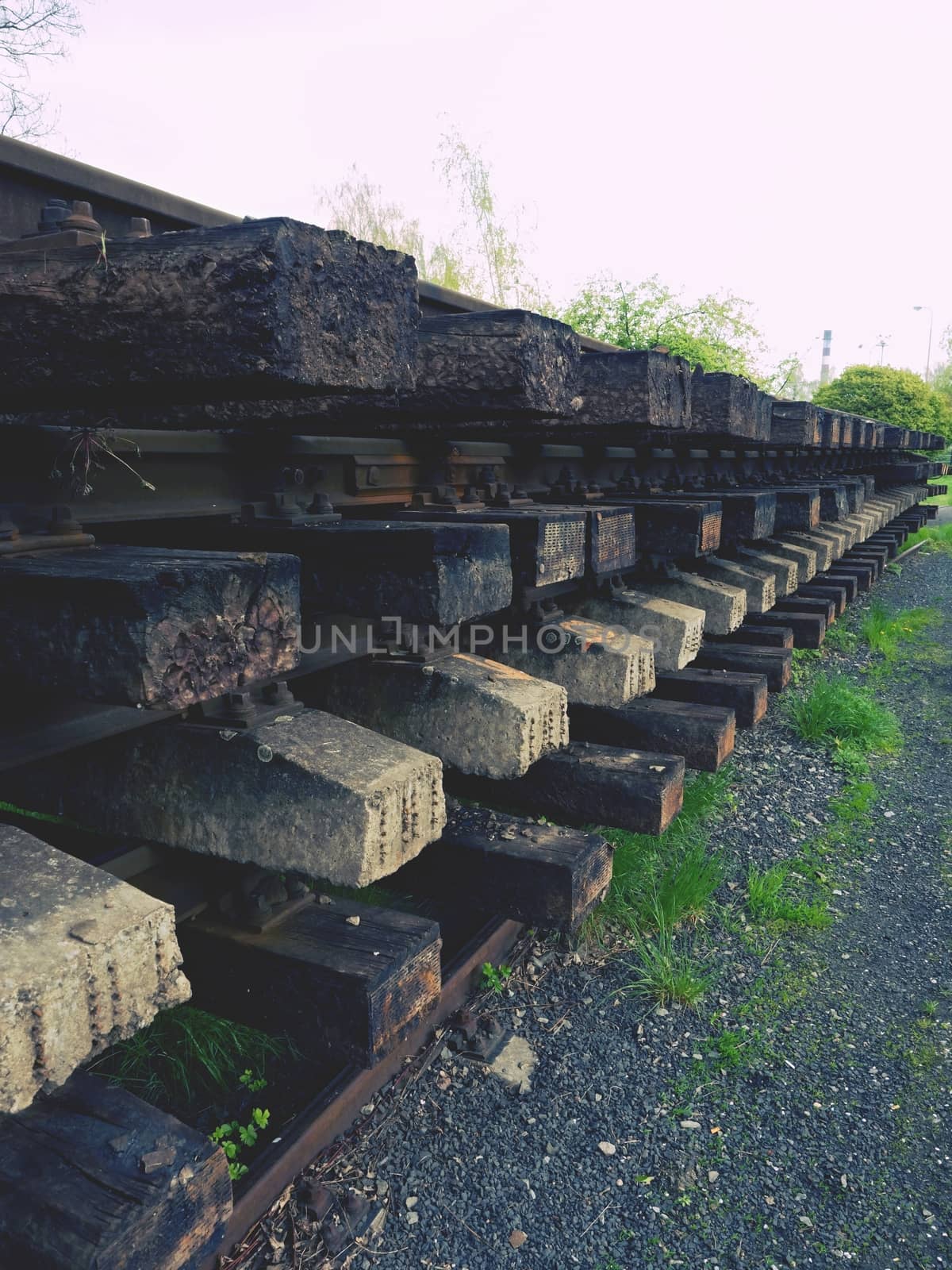 Wagon with extracted old railways. Concrete and wooden sleepers with rail rods in railway station stock waiting for transport to steel foundry for recycling.