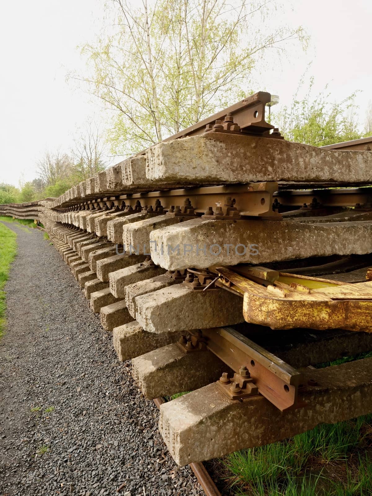 Recycling company stock. Rail platform with old concrete and wooden sleepers extracted  with rail rods waiting for transport to steel foundry for remelting