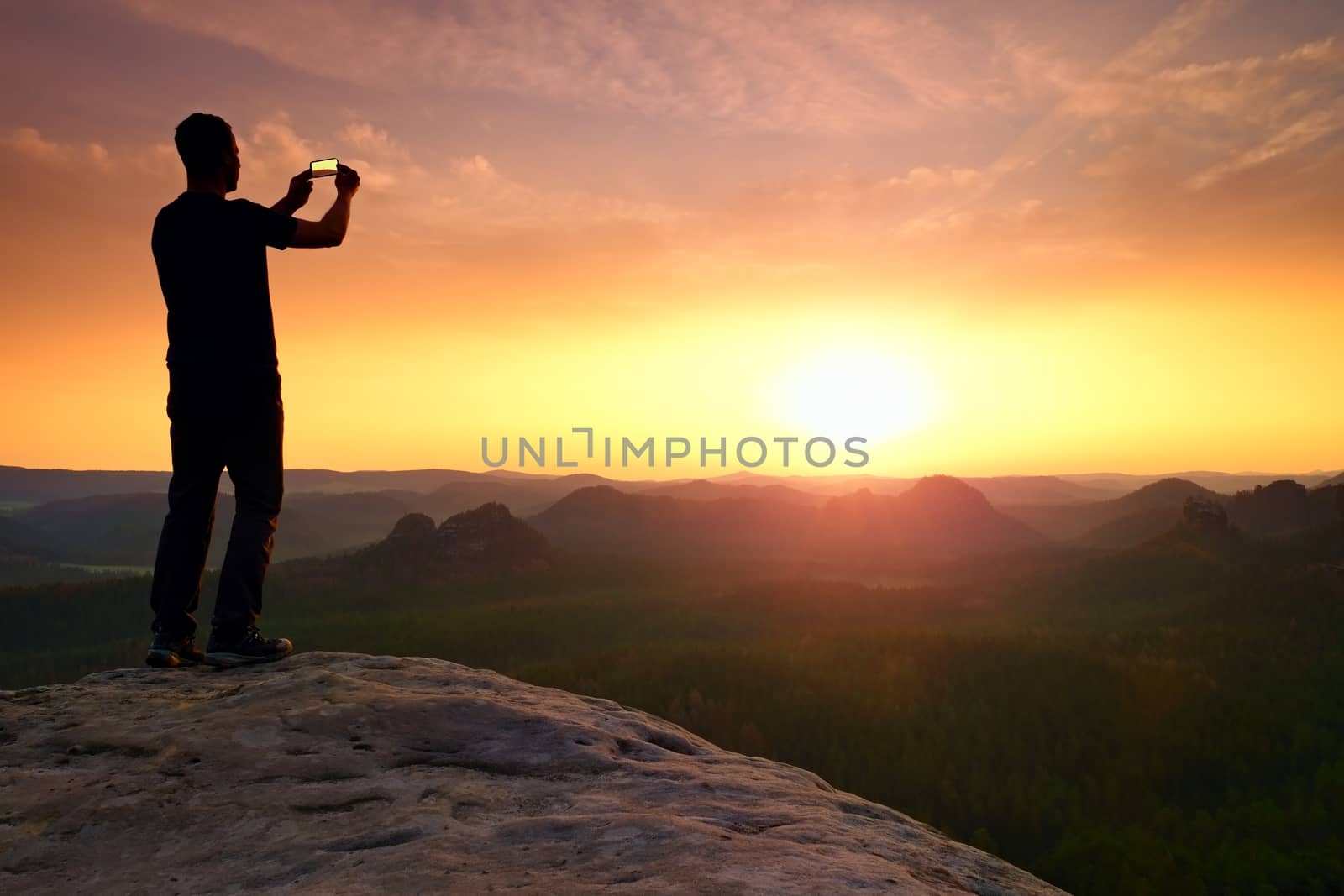 Tall hiker in mountains. Thinking man silhouette in nature within daybreak. The vignetting effect.