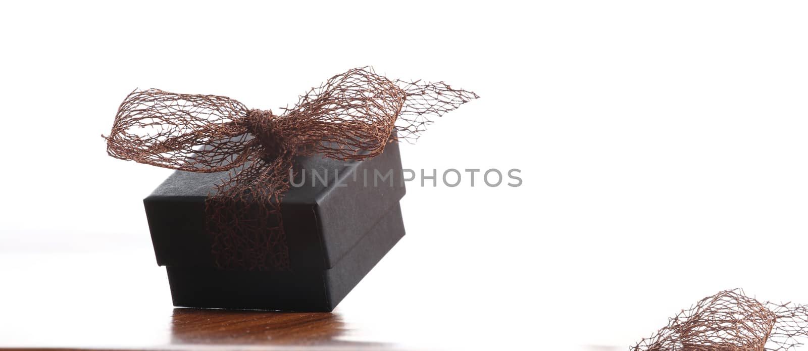 brown christmas present with ribbon. Presents in a table with decoration and copy space and a ribbon