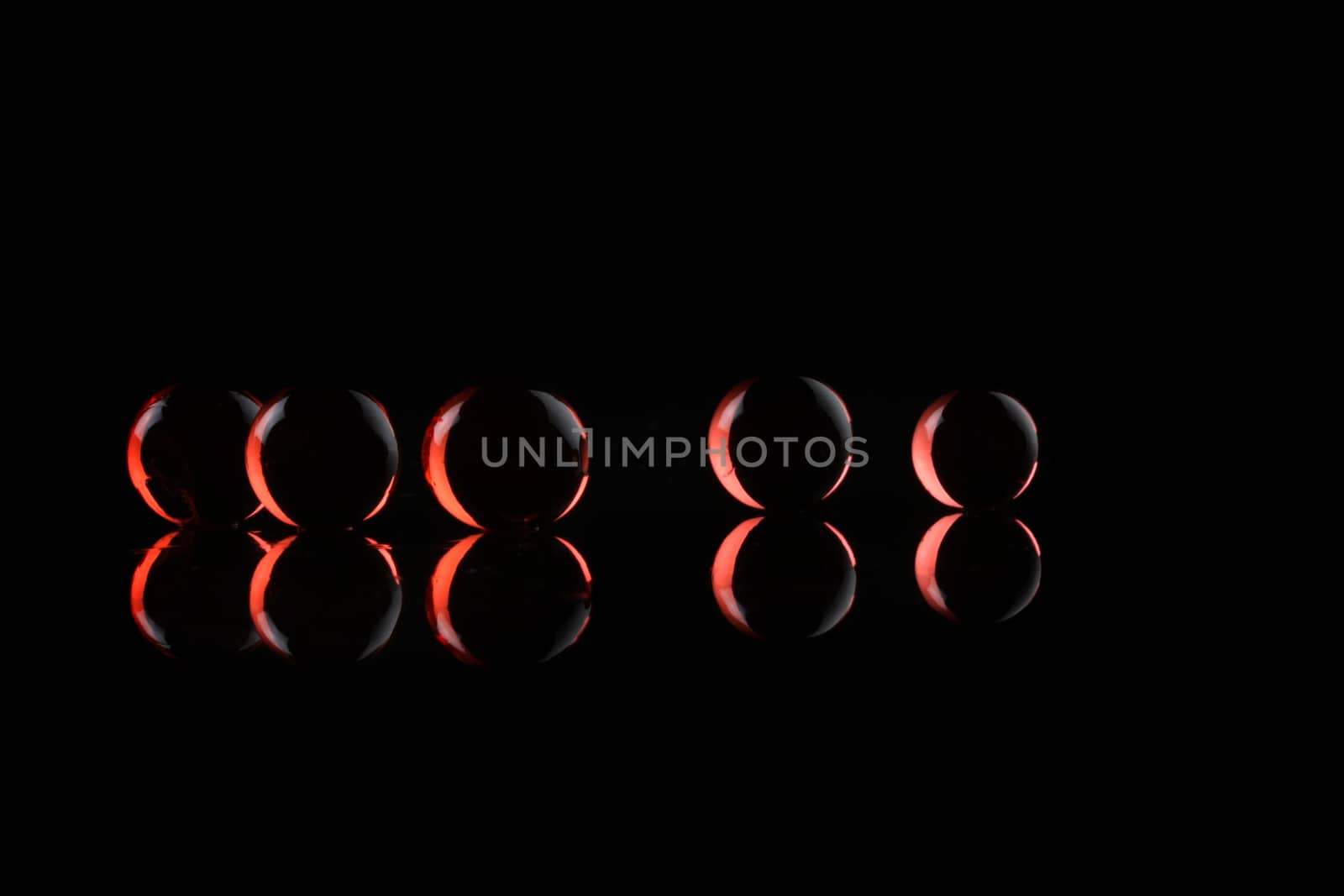 glowing red balls ob black background with reflection - concept shot with copy space