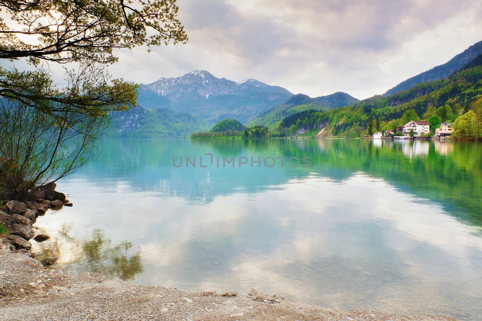Mountains lake and low mountains with snowy peaks in water mirror. Lake in National Park.