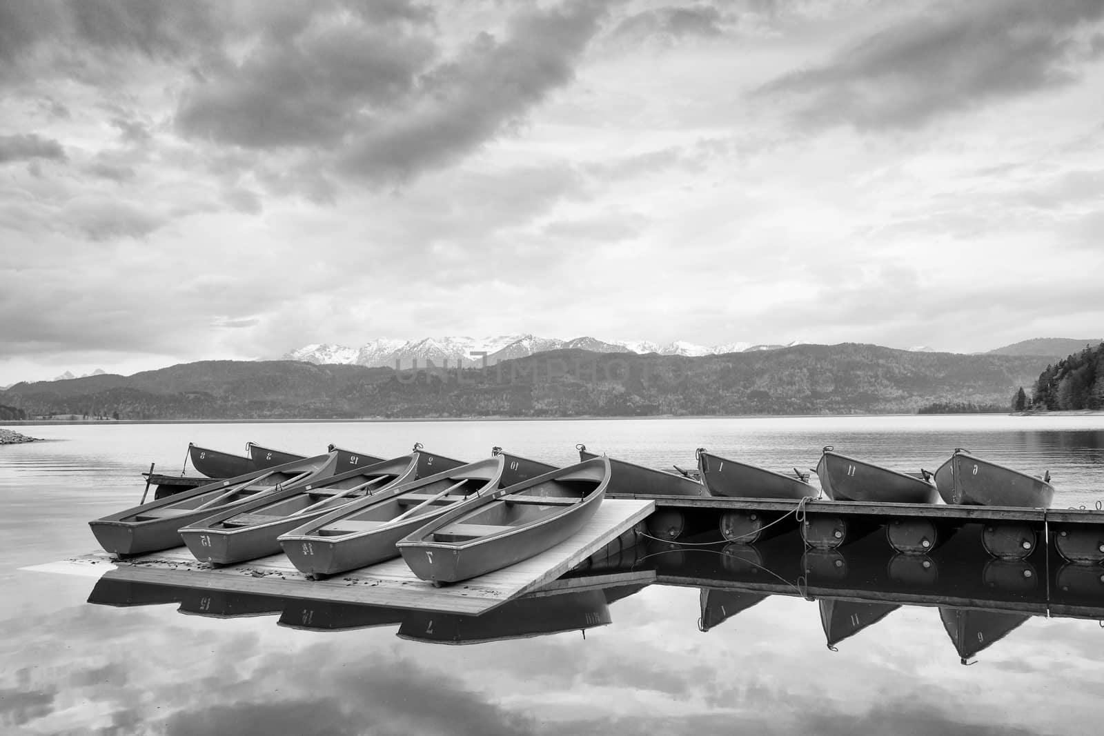 Blue Alps lake with Rental rowing boats in marina. Wharf for trip ships.