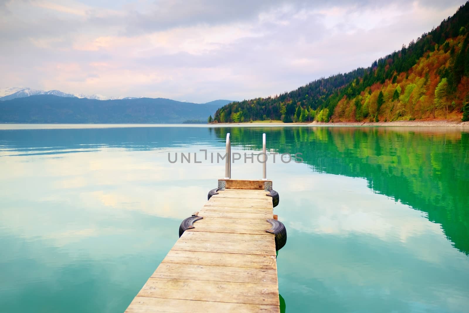 Empty wooden mole on  blue Alps lake, wharf for hired boats in marina. Ready for trip ships.