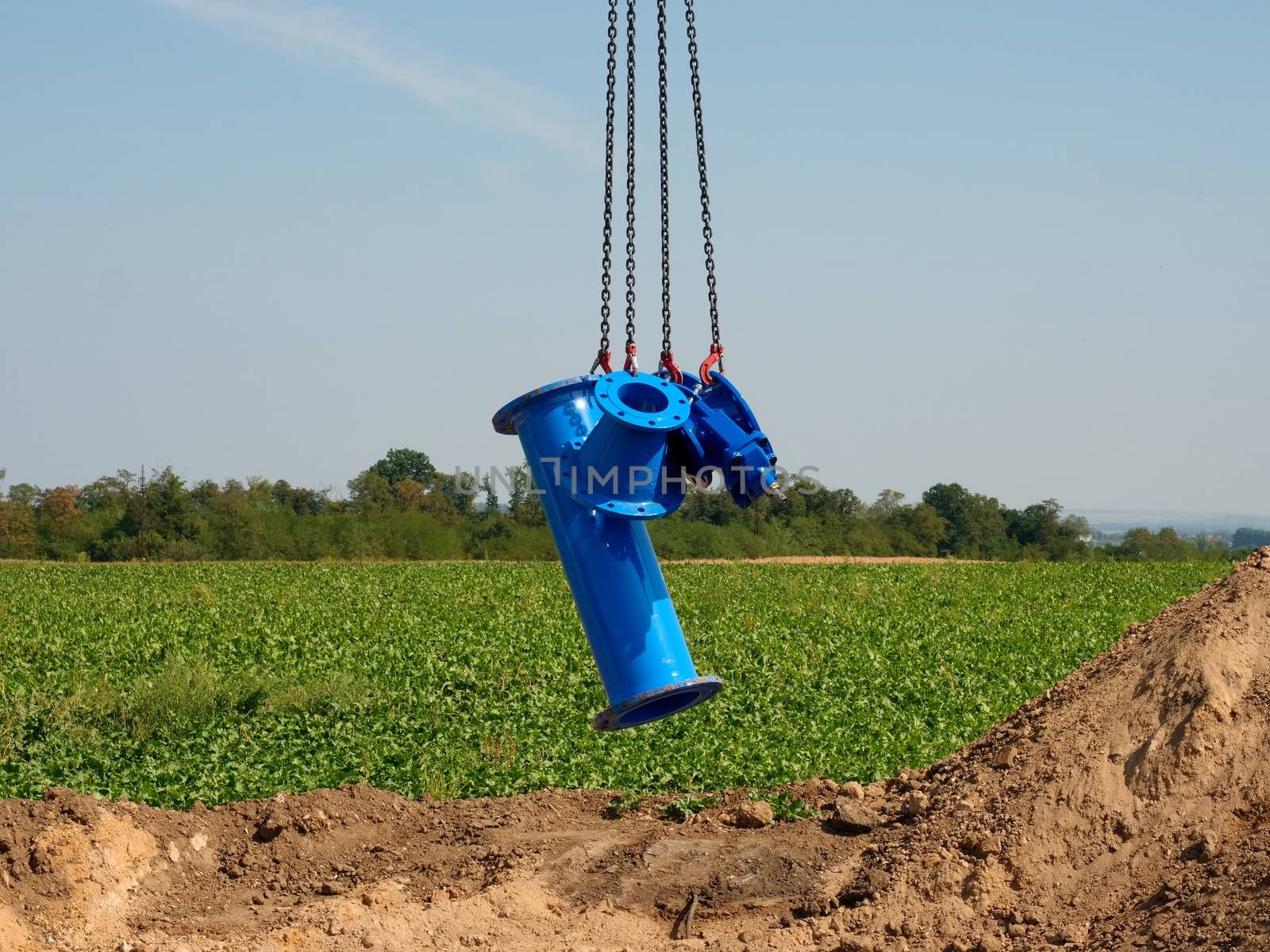 New pipeline part hanging on crane hook. Transport of gate valve within conctruction period by crane.