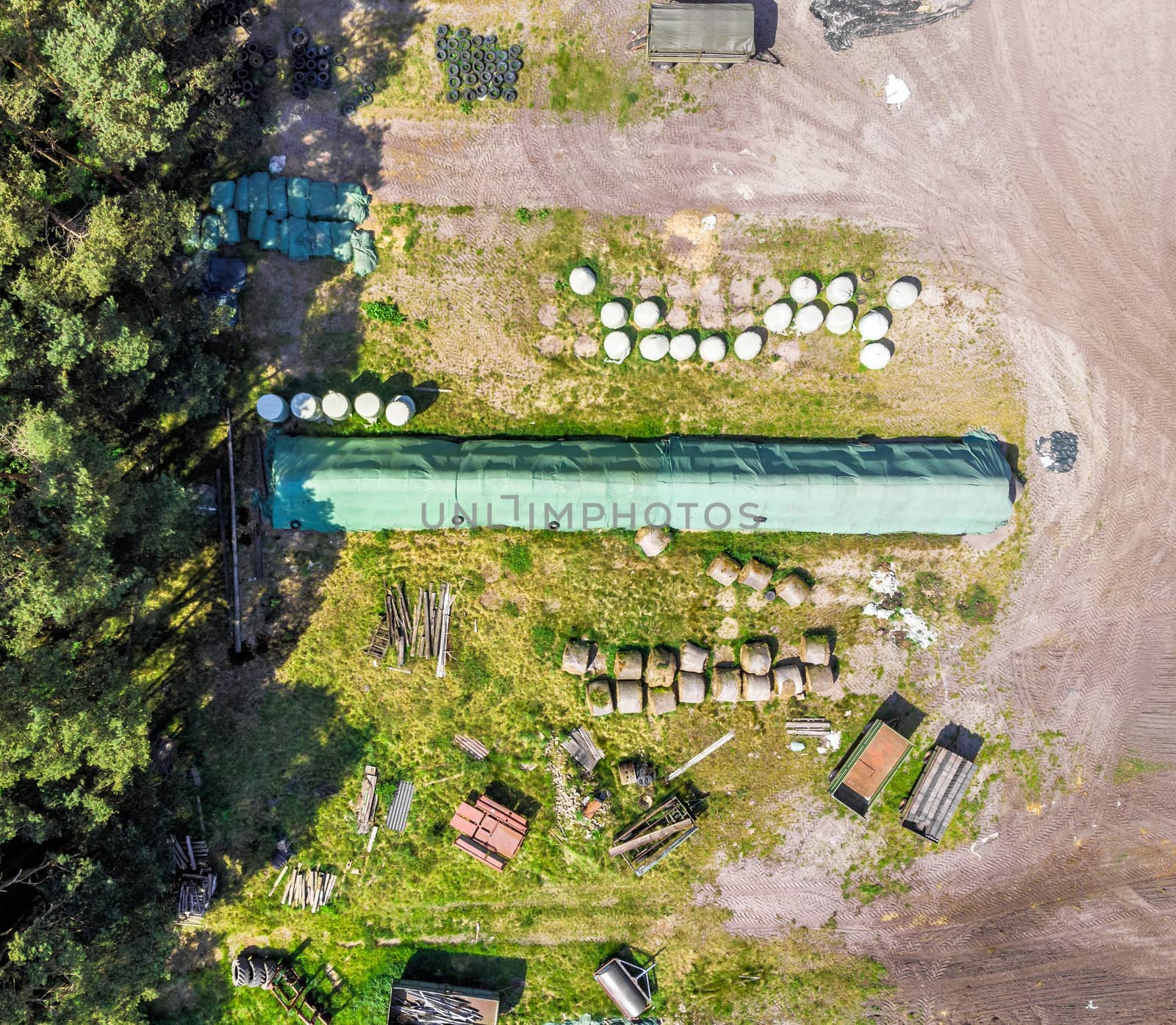 Detailed view from the air of a storage place for a farm, with silage, hay and straw, aerial view, made with drone