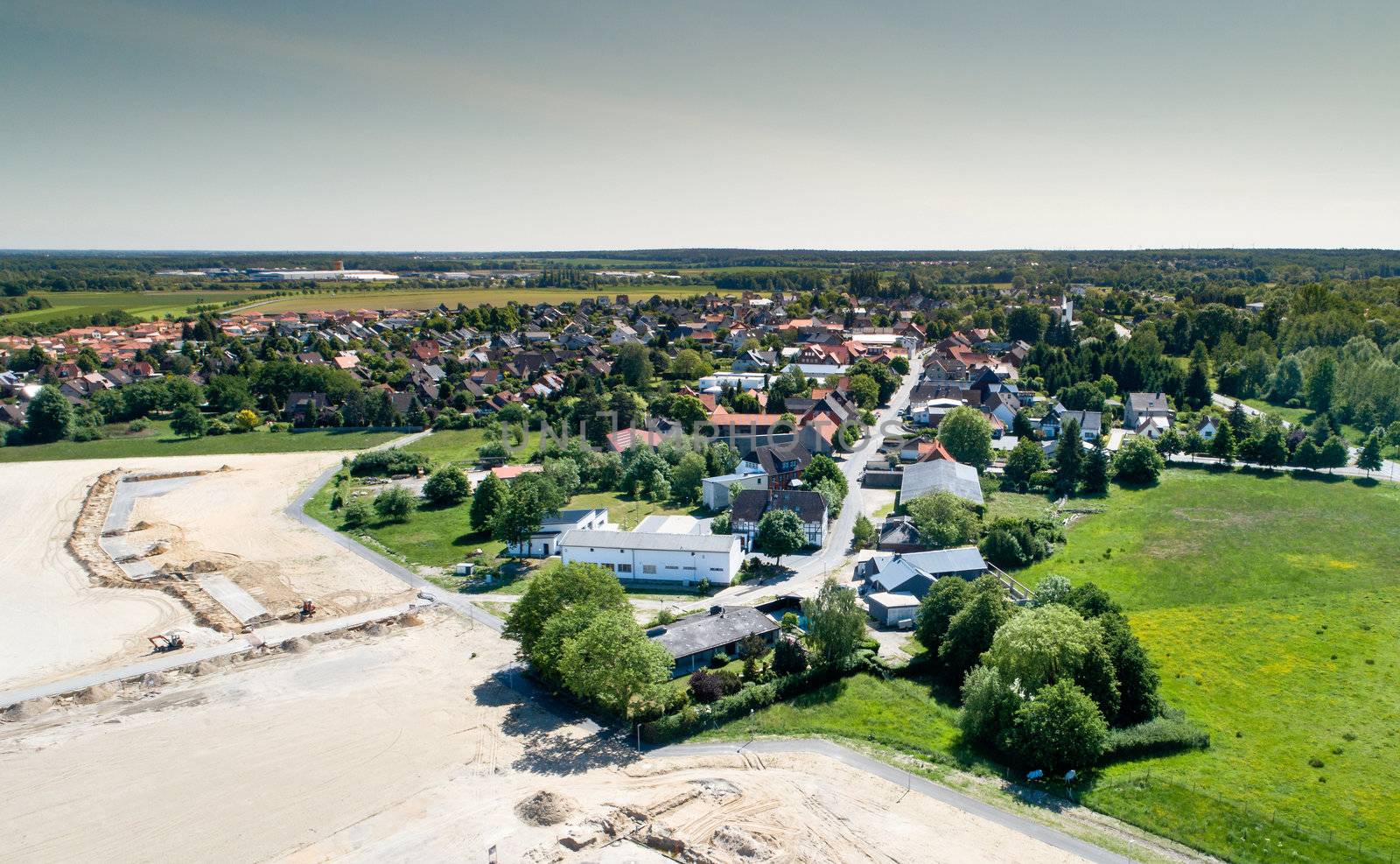 Aerial view from the construction site of a new development area to the old village centre of a suburb by geogif