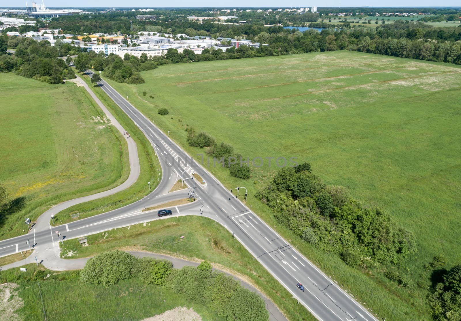 Aerial view of the turn-off of a ring road with the houses of the dominion in the background, near Wolfsburg