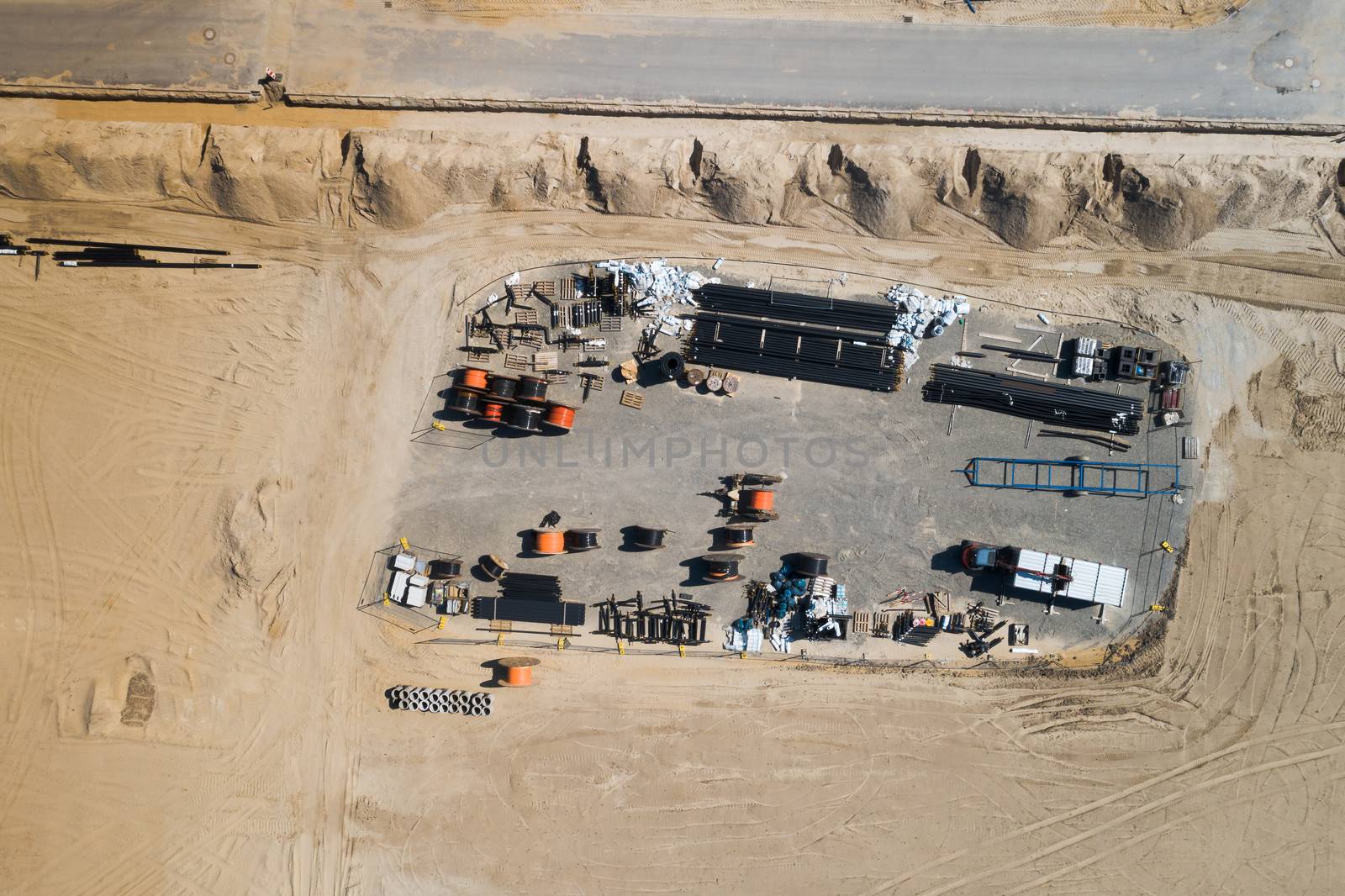 Aerial view of the warehouse of a construction company at the edge of the construction site for a new building area with building materials by geogif