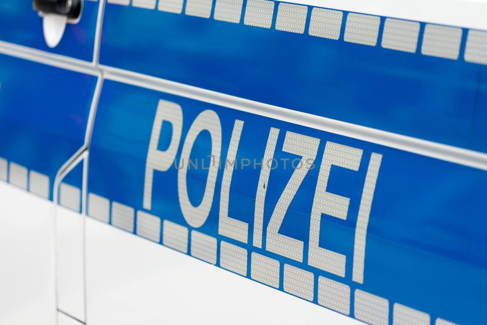 Inscription "Police" in white luminous colour on a blue background on the side of a police car by geogif