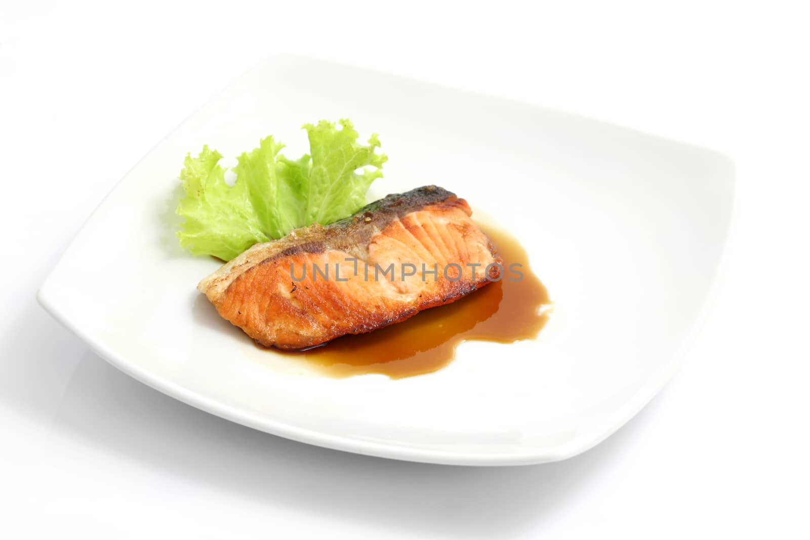 grilled salmon with teriyaki sauce isolated in white background by piyato