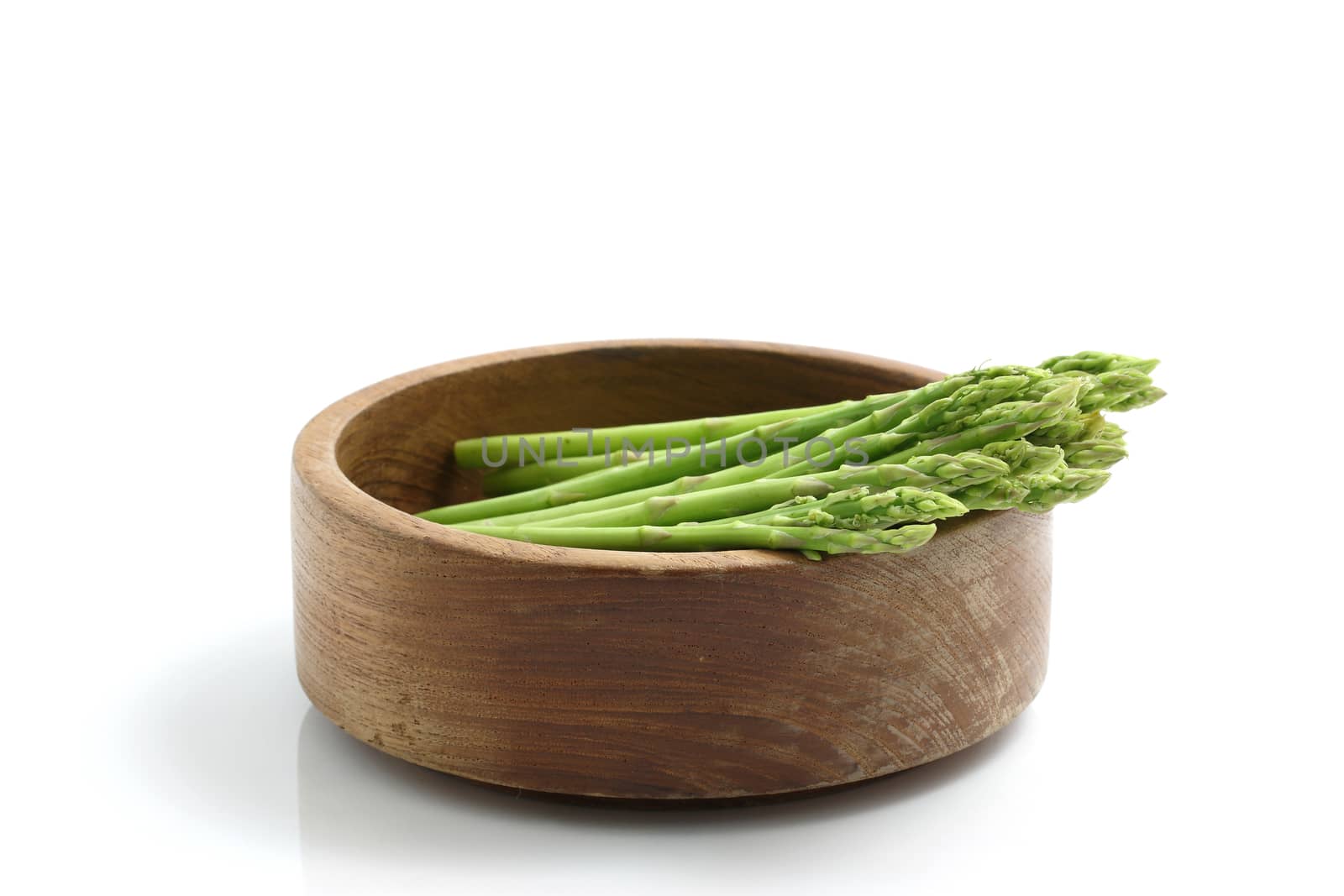 Asparagus on wood bowl isolated in white background by piyato