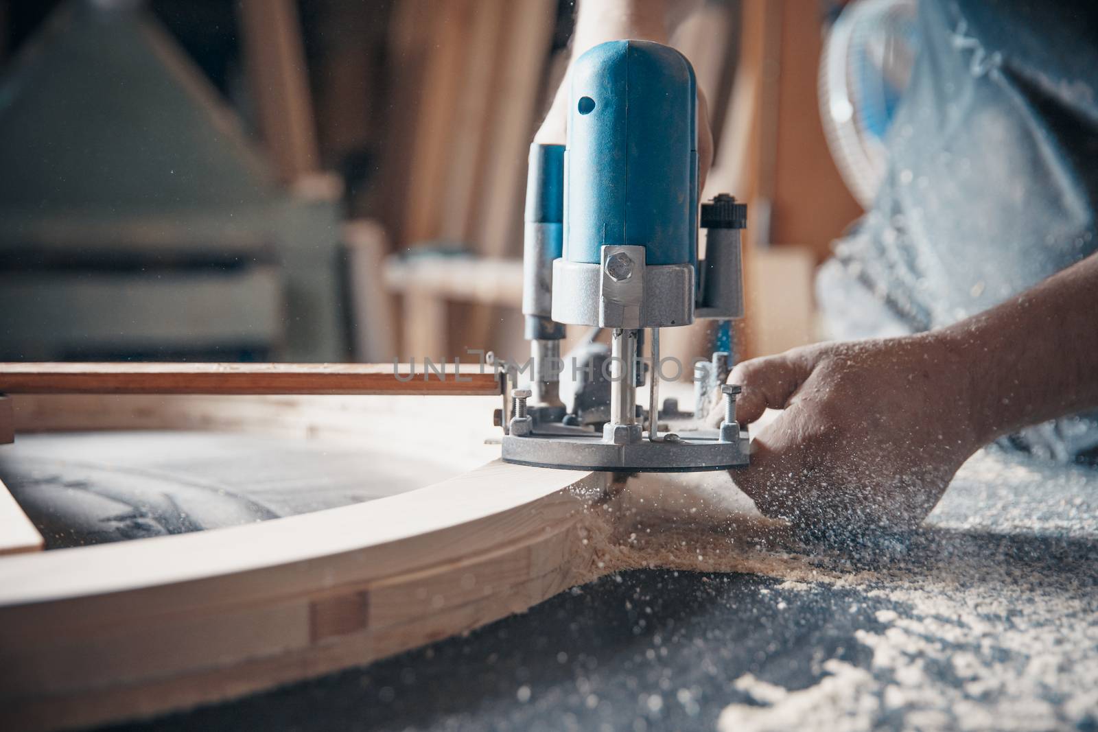 Milling wood in the joinery using manual mechanical cutters. Flying sawdust in the air. Copy space