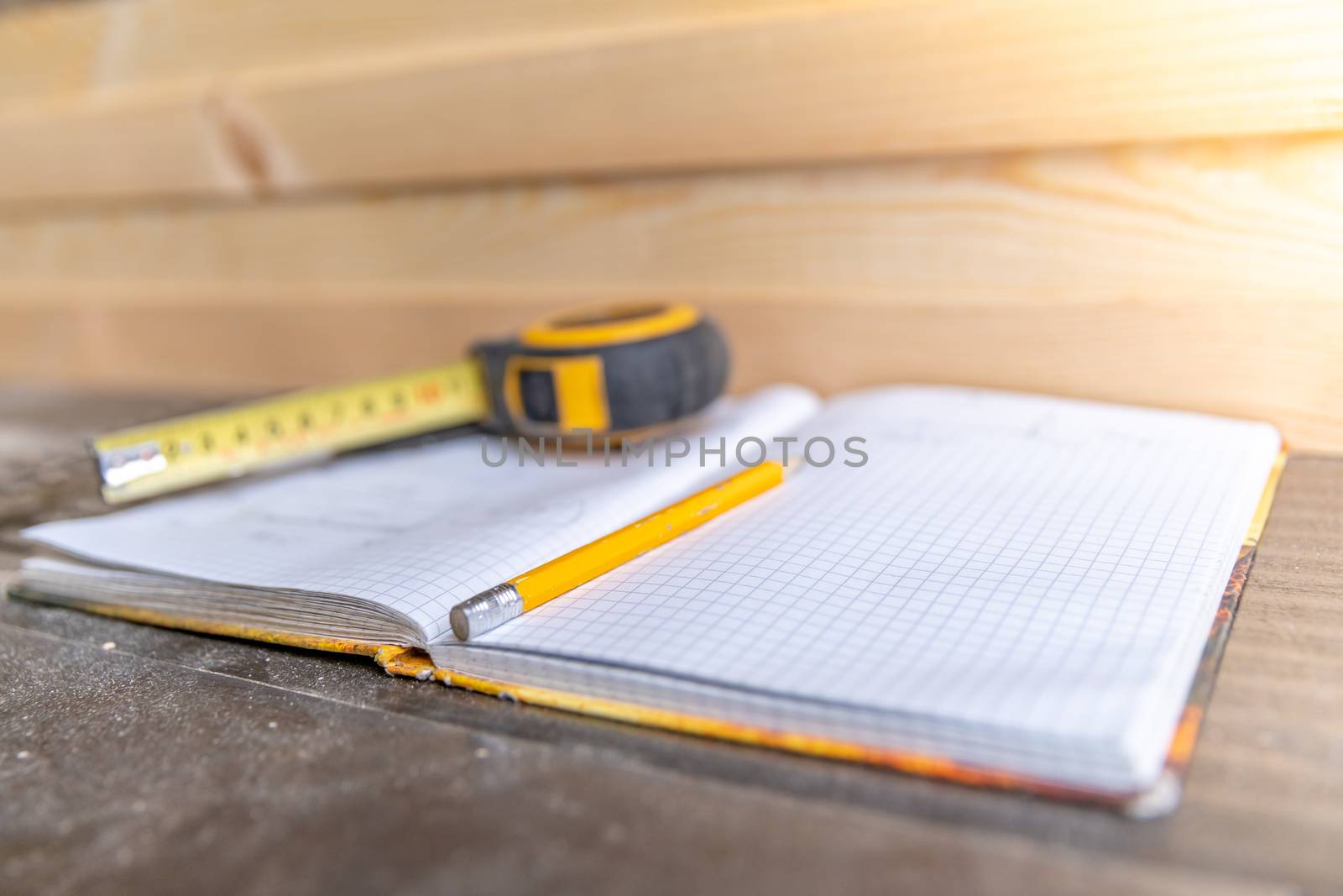 workbook, pencil and meter for planning wooden furniture in joinery.