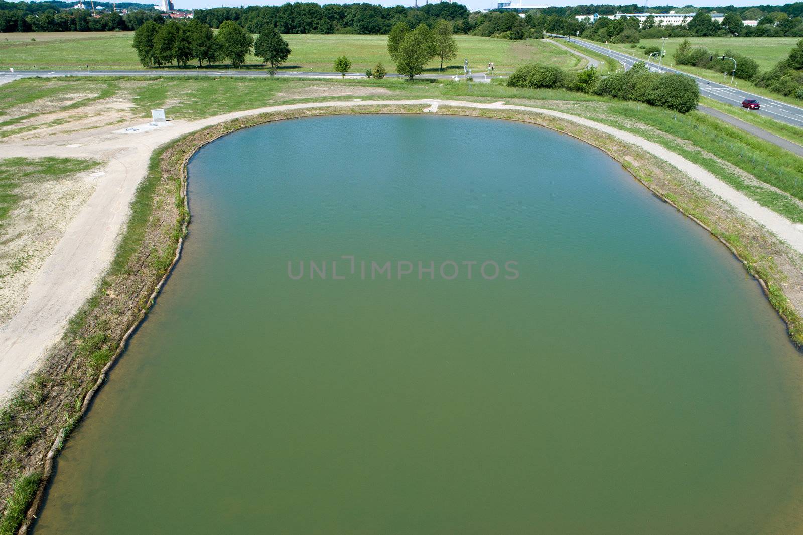 Rainwater retention basin with turquoise coloured water, taken diagonally from the air with a drone by geogif
