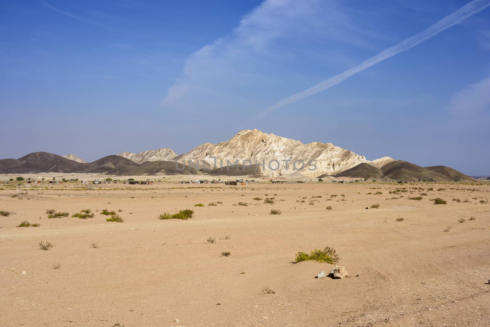 Panorama with a village in the desert and mountains in Ras Al Jinz, Oman