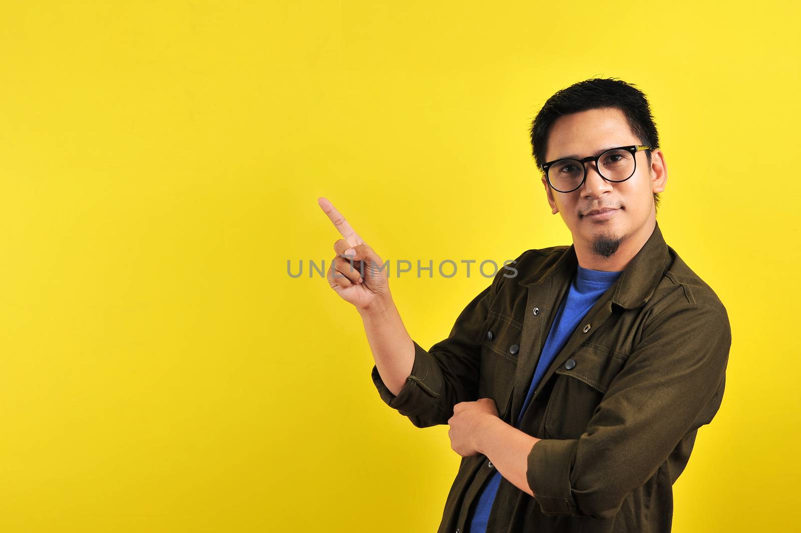 Handsome of happy smiling asian man pointing of a copyspace by heruan1507