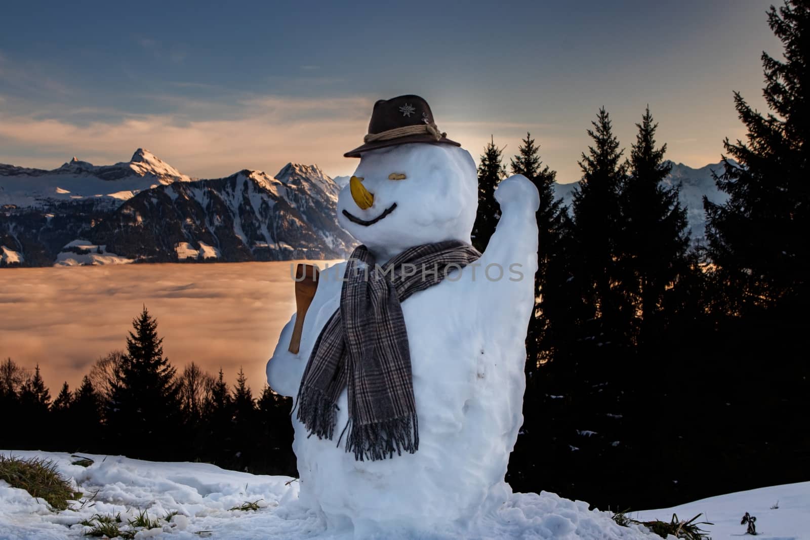 snow man in the swiss alps during sunset