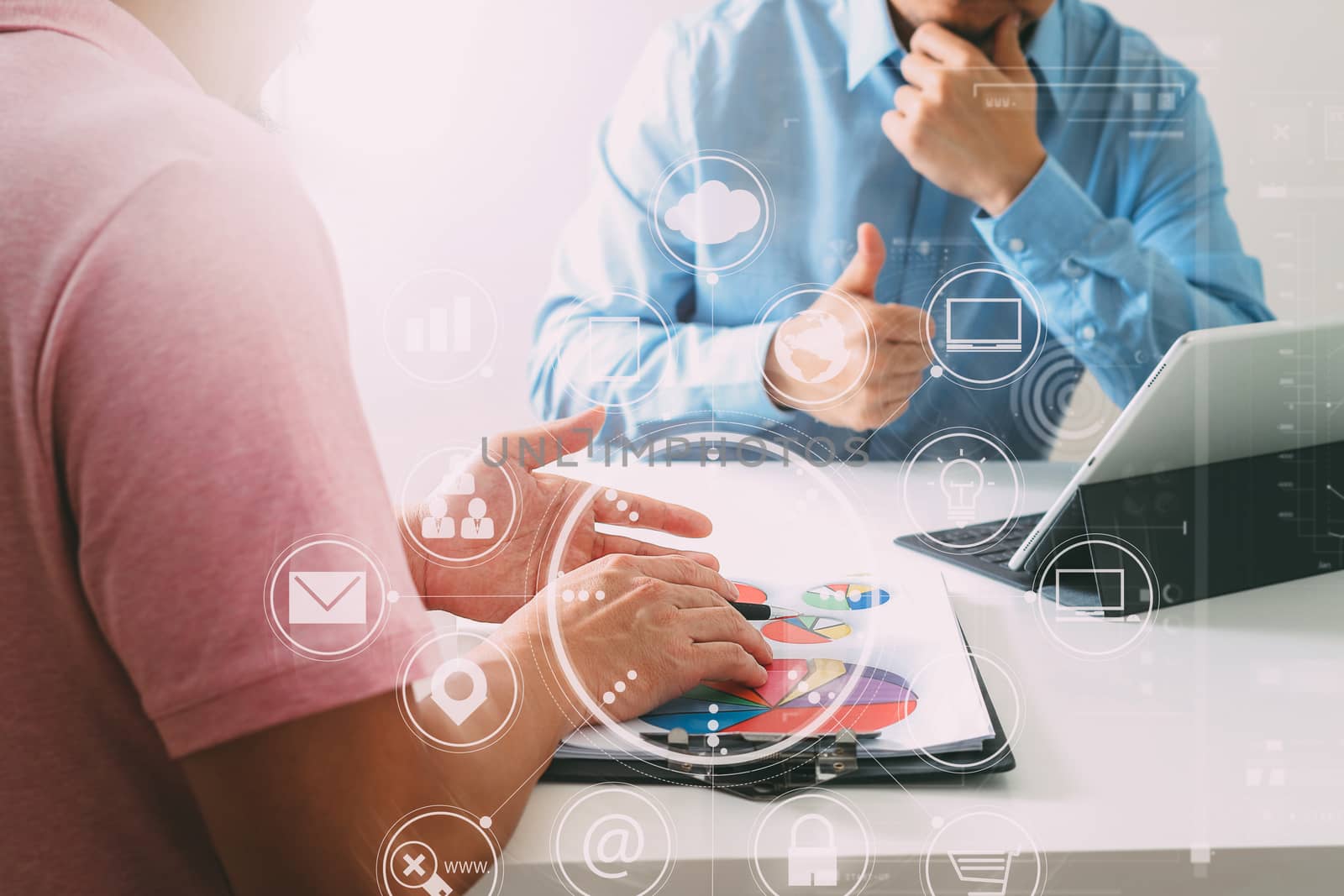 Businessmen working together on a document and using smart phone and digital tablet and laptop computer in modern office with VR icon diagram                                                              