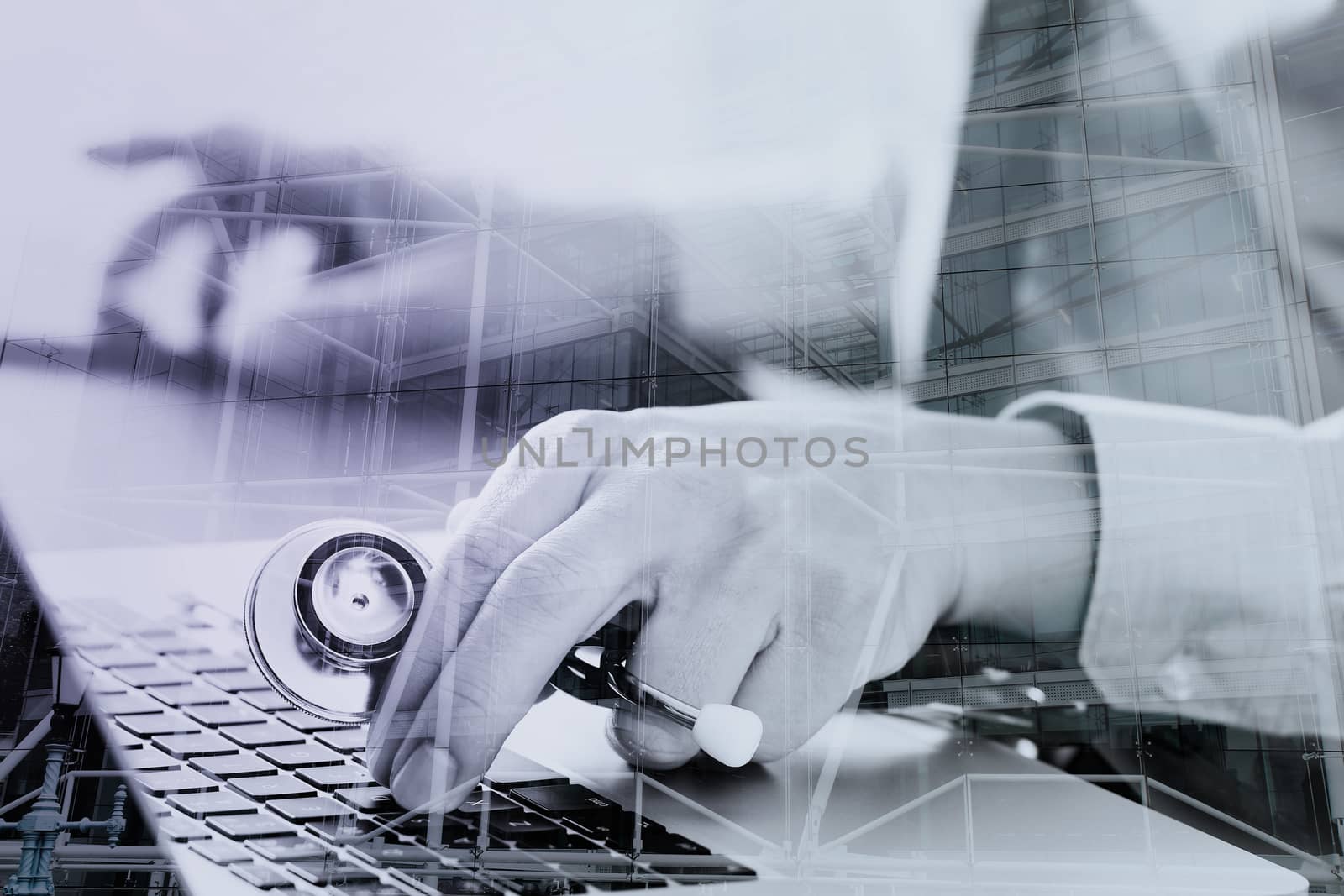 close up of smart medical doctor working with laptop computer and stethoscope on dark wooden desk with London city exposure