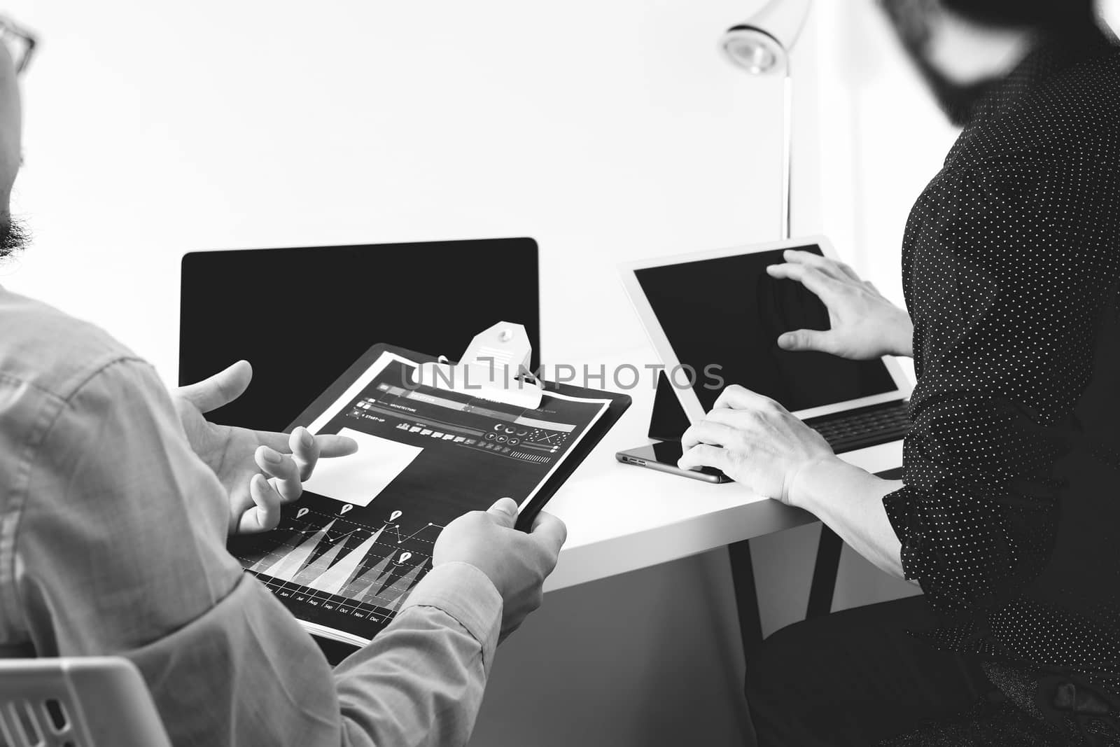 co working team meeting concept,businessman using smart phone and digital tablet and laptop computer in modern office,black and white